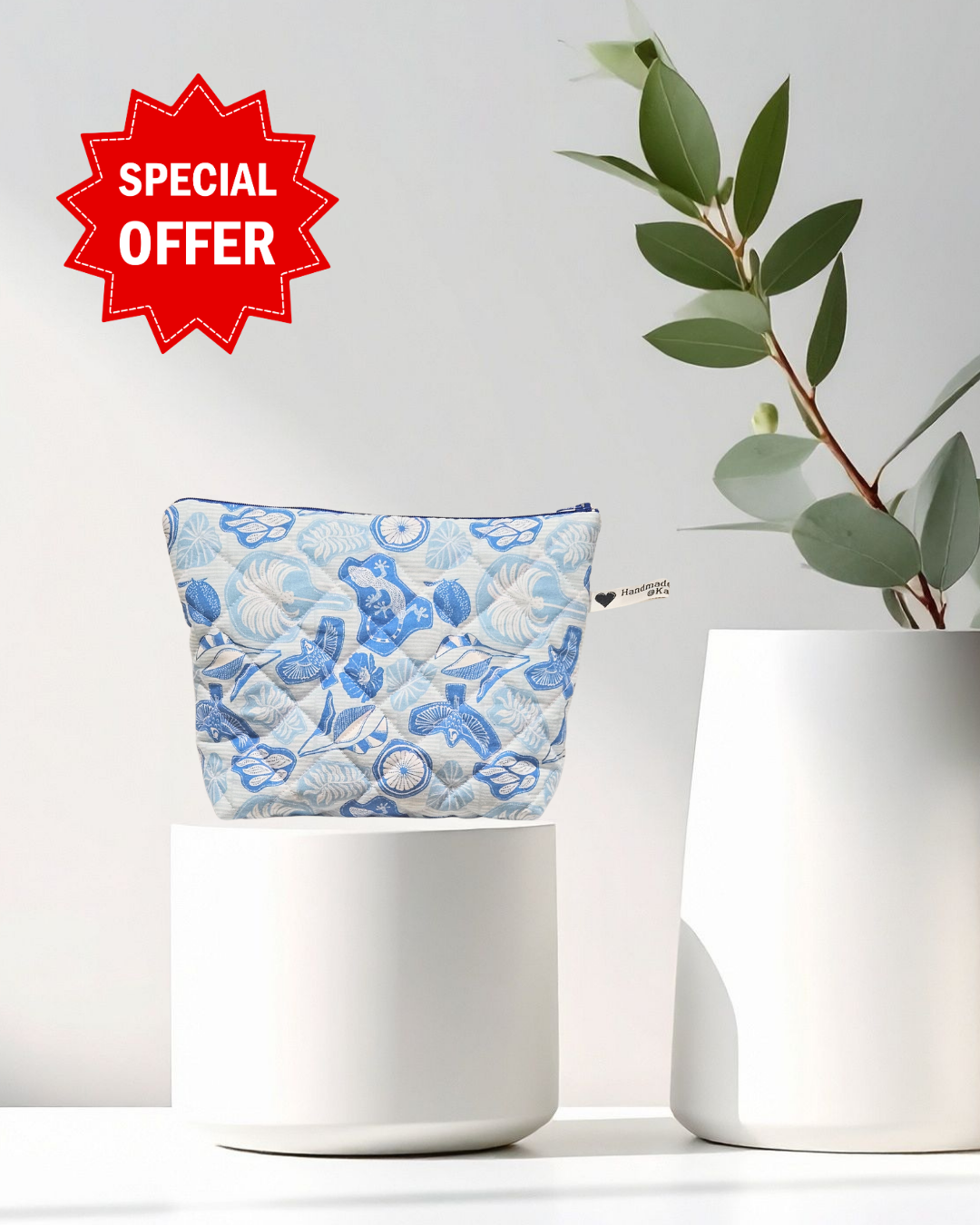 Blue floral pouch on a white surface with a plant and 'Special Offer' sign.