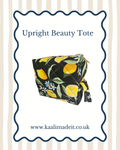 A quilted upright beauty tote bag with a black background and a yellow lemon and green leaf pattern, shown on a white card with a blue wavy border and the text 'Upright Beauty Tote' and 'www.kaalimadeit.