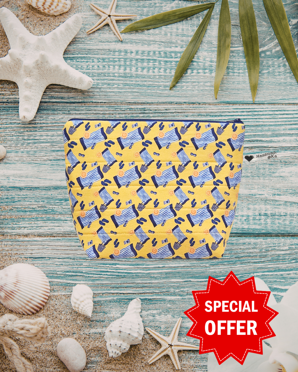 Yellow and blue patterned pouch on a textured surface with shells and starfish