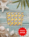Yellow and blue patterned pouch on a textured surface with shells and starfish