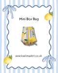 A mini box bag with a yellow and green lemon print, centered on a white background with a blue wavy border, bows, lemons, and the text 'Mini Box Bag' and 'www.kaalimadeit.
